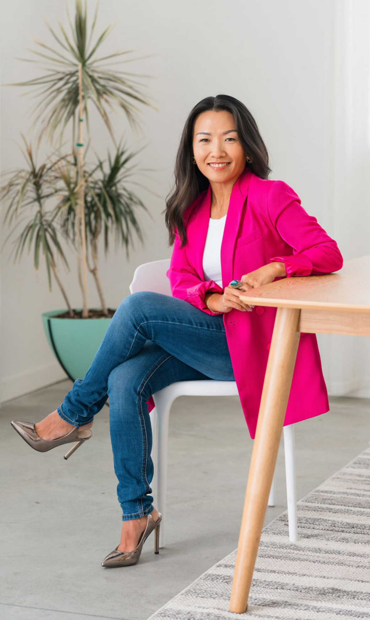 Weiwei "Vivian" Fellman sitting at a table smiling at camera